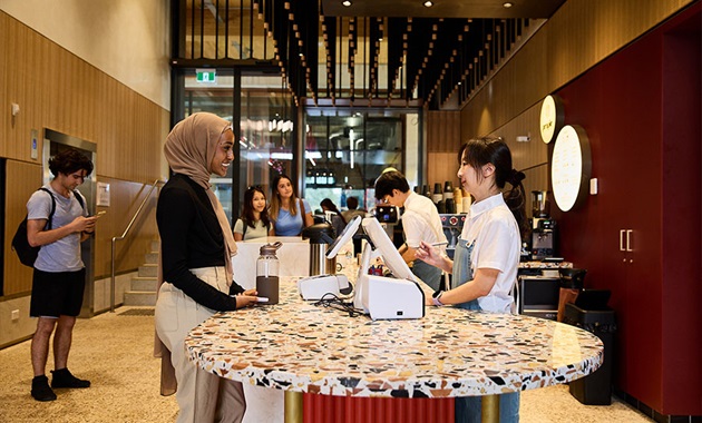 Woman buying coffee at cafe