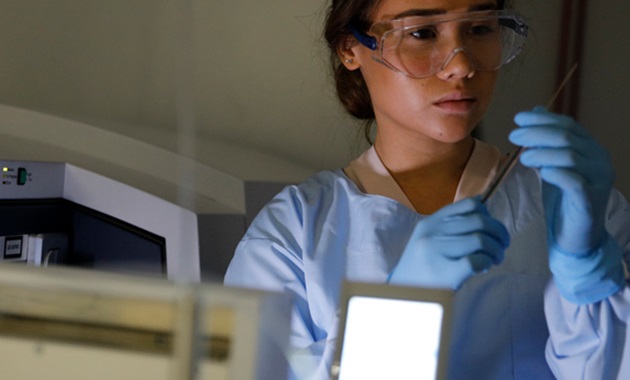 Understanding early childhood disease risks researcher in PPE handling syringe