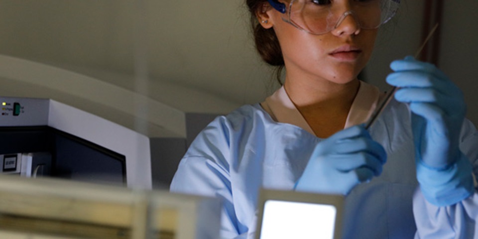 researcher in PPE handling syringe