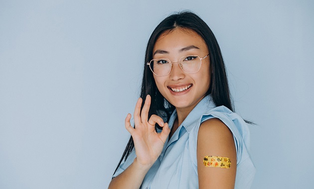 Asian woman smiling after her vaccination