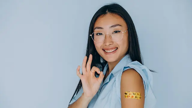 Asian woman smiling after her vaccination