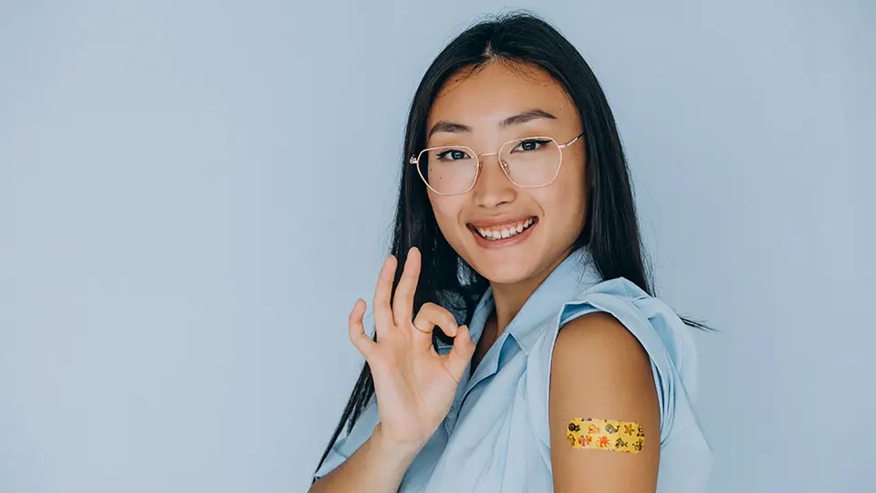 Asian woman smiling after her vaccination