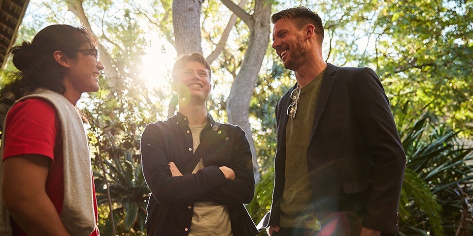 Murdoch University students smiling and talking amongst trees