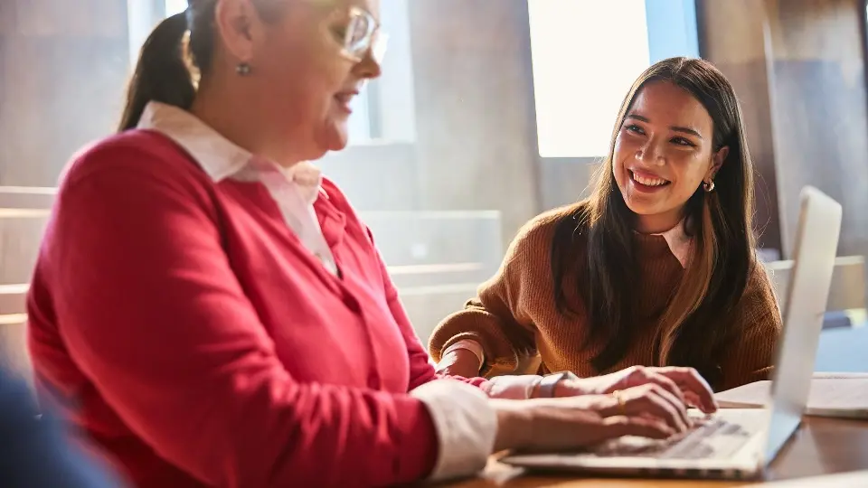 Academic typing on laptop with student