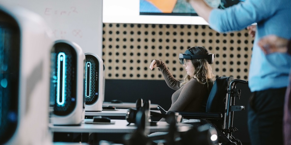 Student gesturing with headset in computer lab