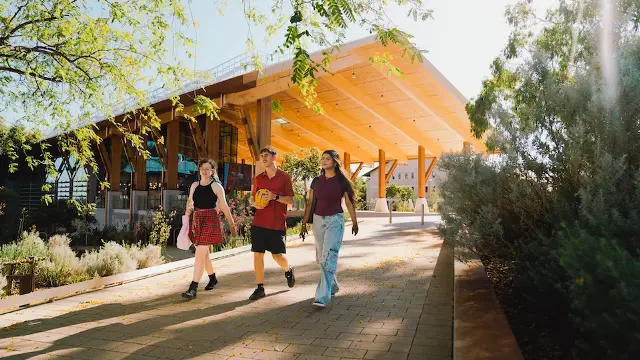 3 students walking outside Boola Katitjin