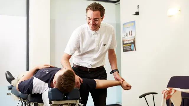 Chiropractor manipulating a client's arm