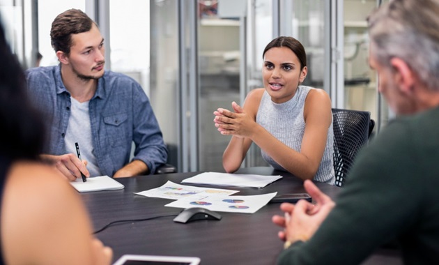 A young woman leading a meeting in an office.