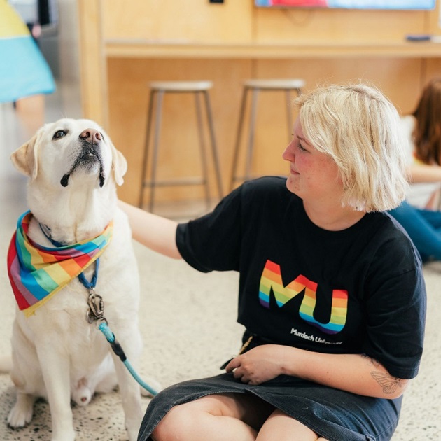 Student with therapy dog at the Den