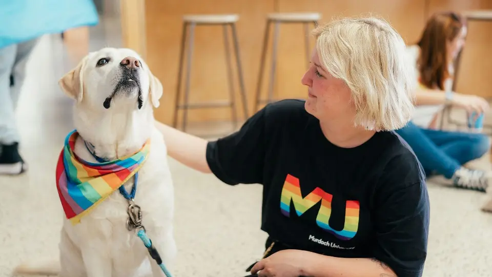 Student with therapy dog at the Den