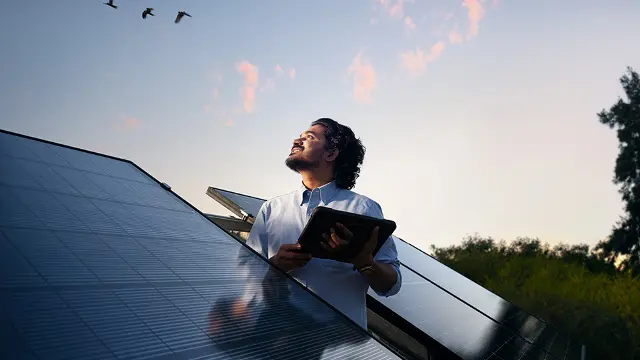 Murdoch student standing next to solar panels
