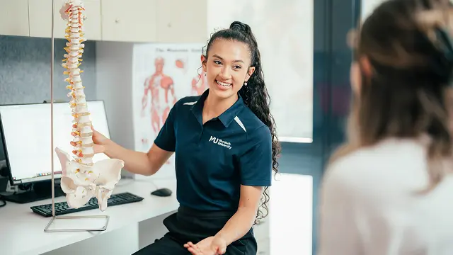Allied health student with spine model