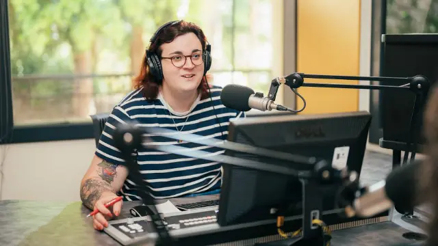Media student hosting a radio broadcast in a recording studio