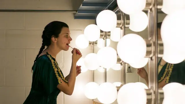 Media student applying makeup under studio lighting