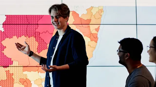 Law and criminology student presenting in front of digital map screen