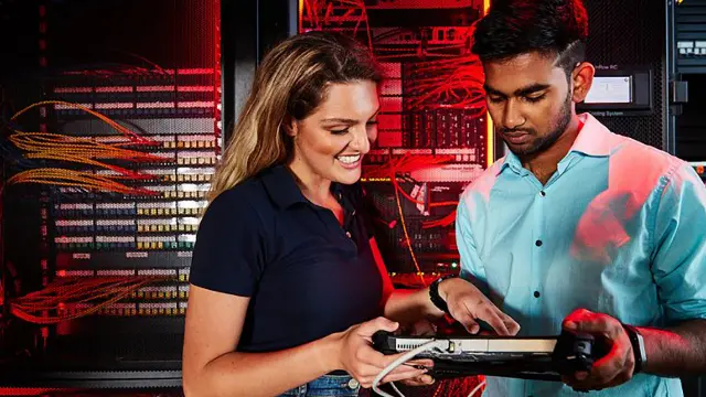 Information technologies students in server room with device