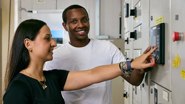 Engineering students inspecting electrical switchgear on campus
