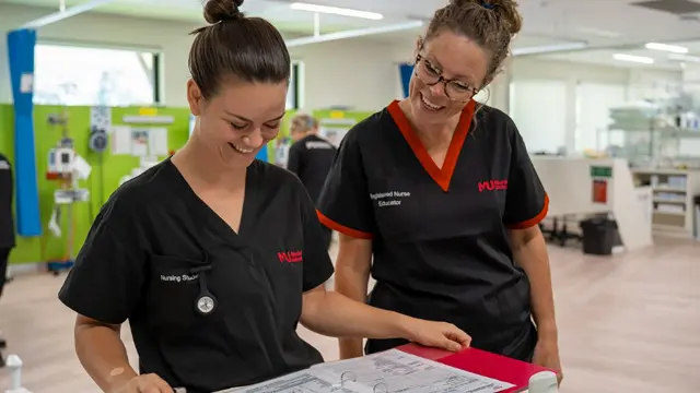 Nursing students reviewing patient notes in a clinical simulation ward