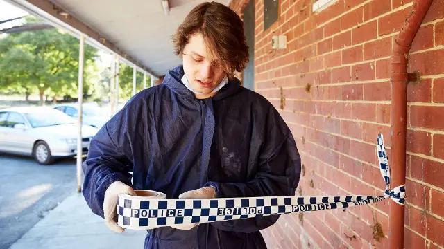 Forensic science student collecting evidence at an outdoor crime scene
