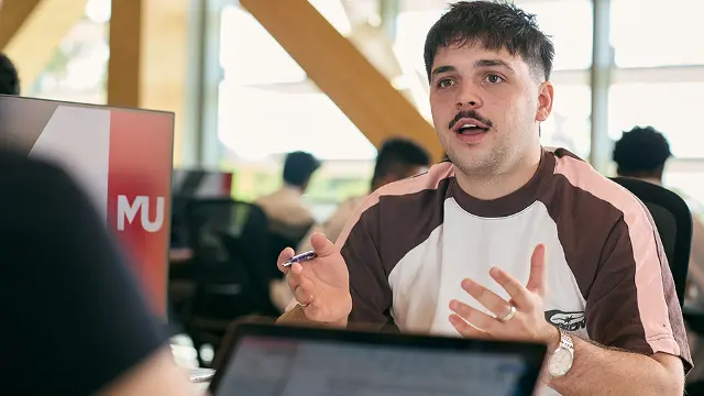 Student presenting to a group using a tablet on campus