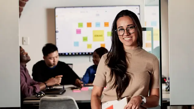 Student presenting ideas on a whiteboard during a workshop