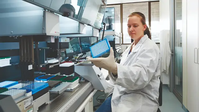 Science student operating analytical equipment in a laboratory