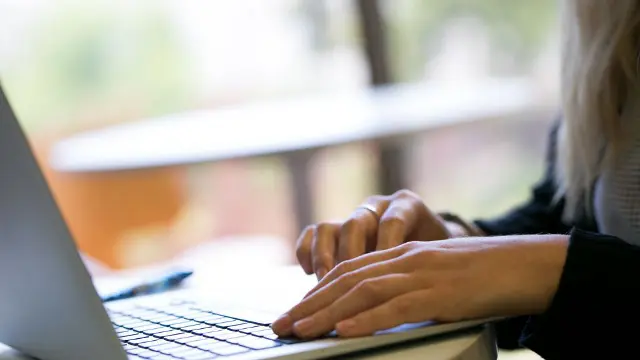 Student typing on a laptop