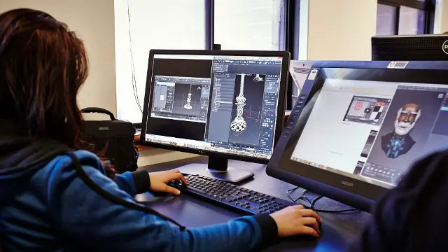 Media student editing video content on a desktop computer