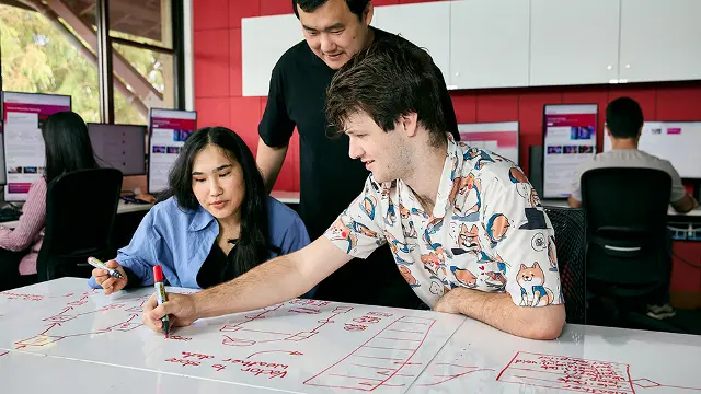 IT students collaborating on a project in a computer lab