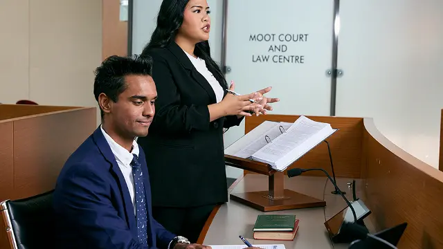 Law student and lecturer in a moot court setting