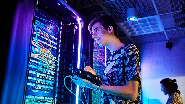 IT student examining an illuminated server or gaming PC build