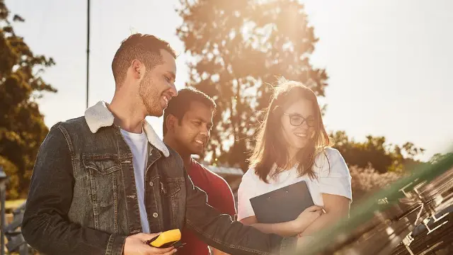 Engineering students collaborating outdoors at a solar energy facility
