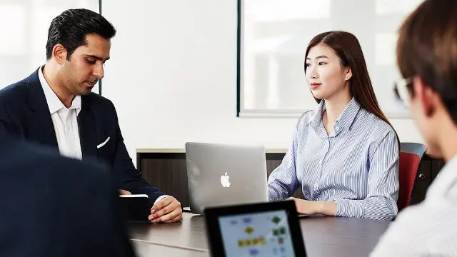 Business students reviewing work together on a laptop