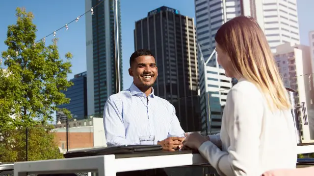 Communications student networking with a professional in a city setting