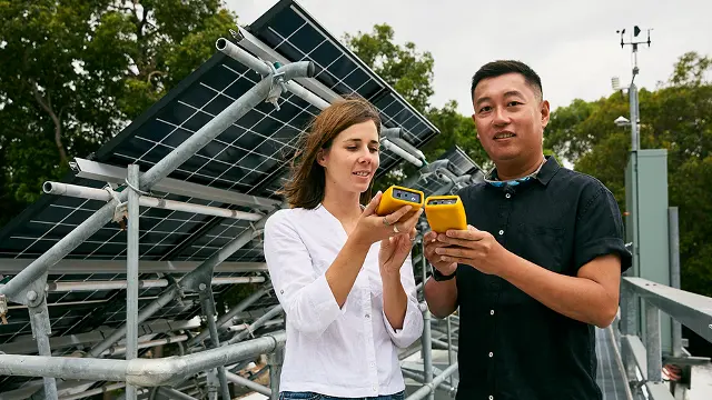 Engineering students examining a solar panel installation