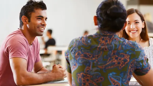 Students smiling together in a campus café or study area