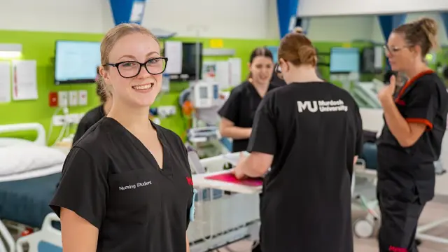 Nursing student smiling in a clinical simulation ward
