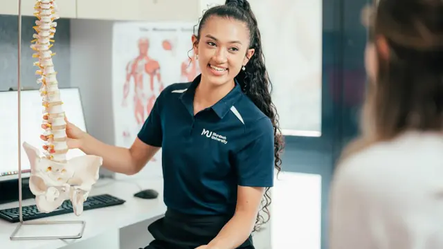 Allied health student with spine model