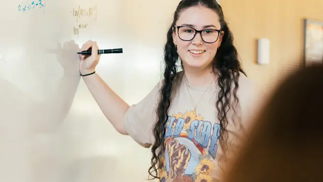 Physical Sciences and Mathematics student writing equation on whiteboard