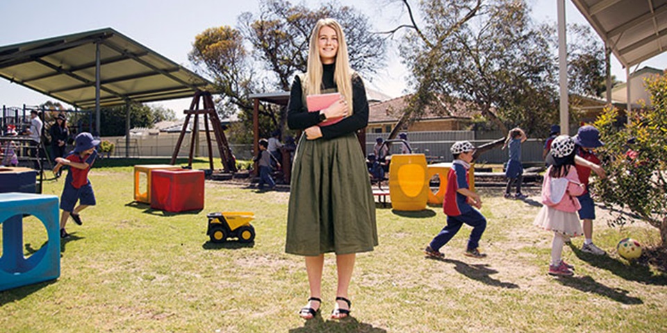 Student teaching in playground with children