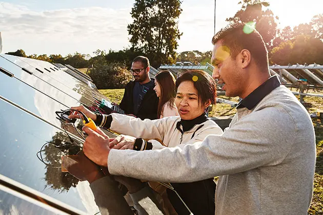 2 people next to solar panel