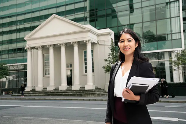 Law student standing in front of law building
