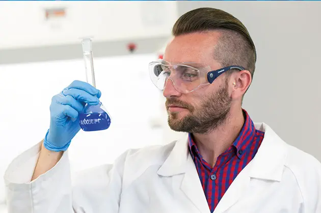 Scientist looking at beaker