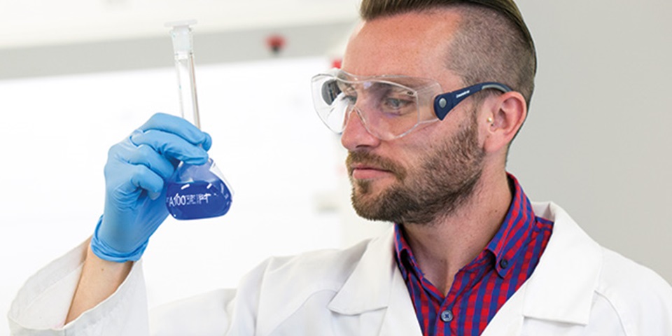 Scientist looking at beaker