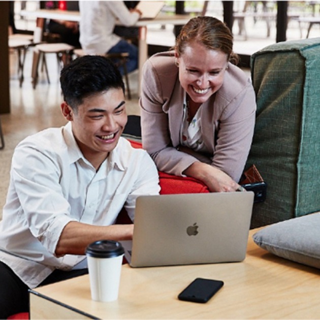 male and female student looking at a laptop screen