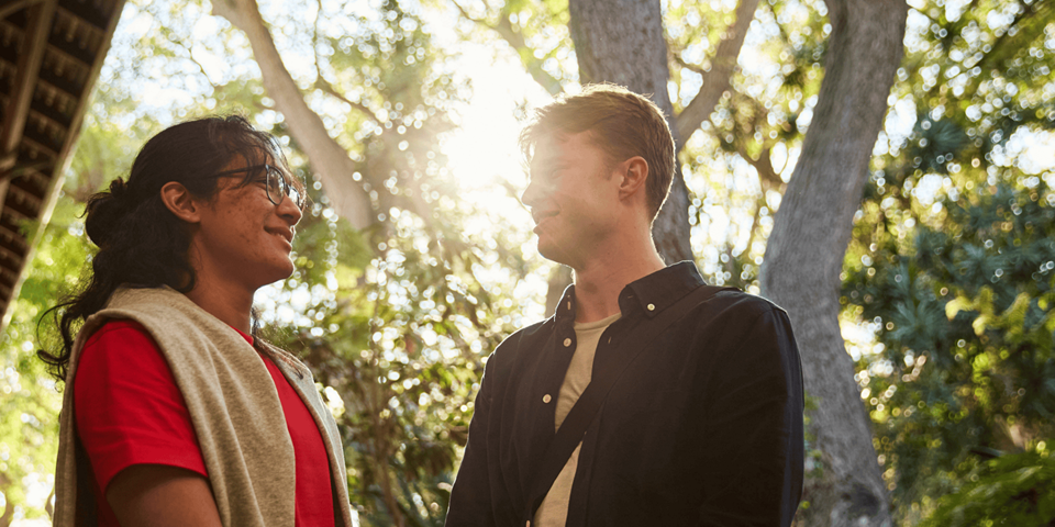 2 male students in front of trees and sunlight