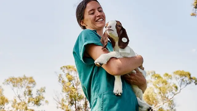 Vet student holding goat