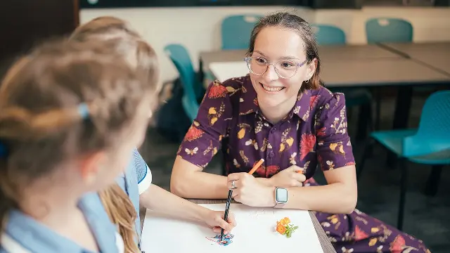 Murdoch University student talking with primary students in classroom