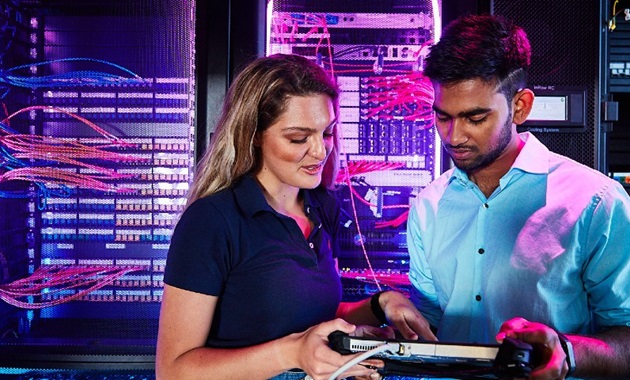 Two students looking at the control panel in the data lab