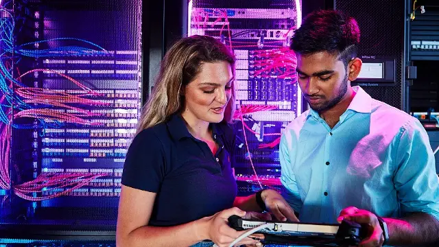 Two students looking at the control panel in the data lab